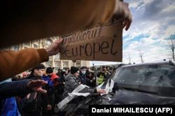 Los manifestantes lanzan papel higiénico y escupen sobre el parabrisas de un coche perteneciente a una misión diplomática mientras irrumpen en el Parlamento el 21 de diciembre.