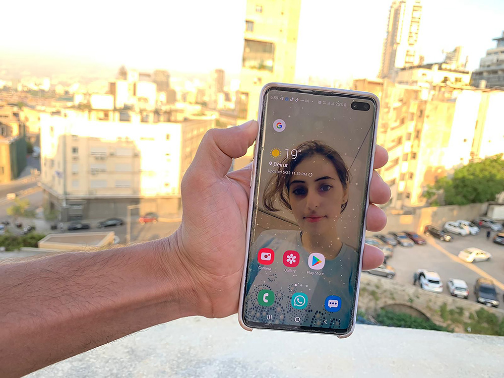 Al-Kino sostiene un teléfono móvil con una foto de su hermana menor, que murió durante la explosión del puerto de Beirut.