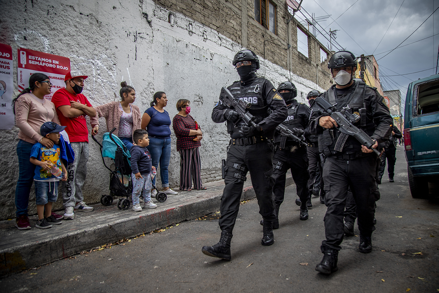 Mujeres y niños cerca de policías armados en la Ciudad de México el 25 de junio de 2020.