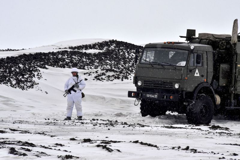 Un miembro del servicio ruso hace guardia junto a un camión militar en la isla de la Tierra de Alexandra, que forma parte del archipiélago de la Tierra de Francisco José en Rusia, el 17 de mayo de 2021.