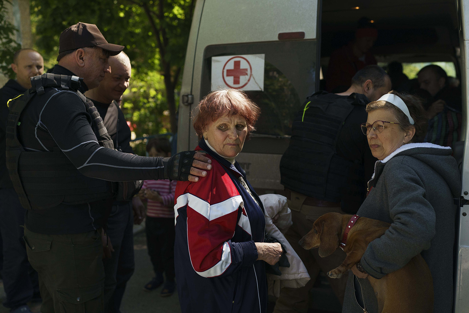 El sacerdote Oleg ayuda a la evacuada de Vuhledar Katya a subir a su furgoneta