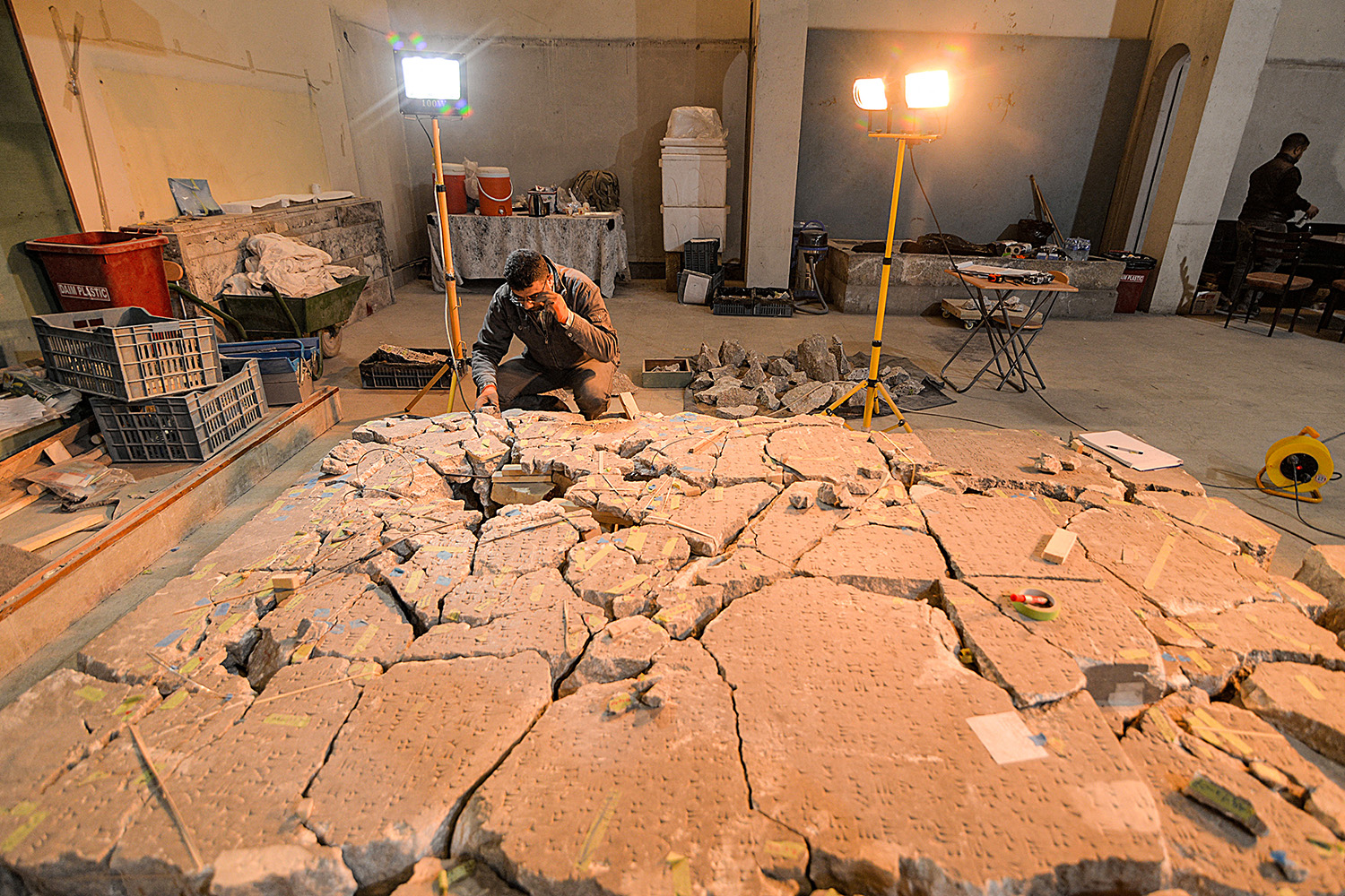 Un trabajador del Museo de Mosul intenta recomponer a partir de fragmentos rotos un artefacto con inscripciones cuneiformes