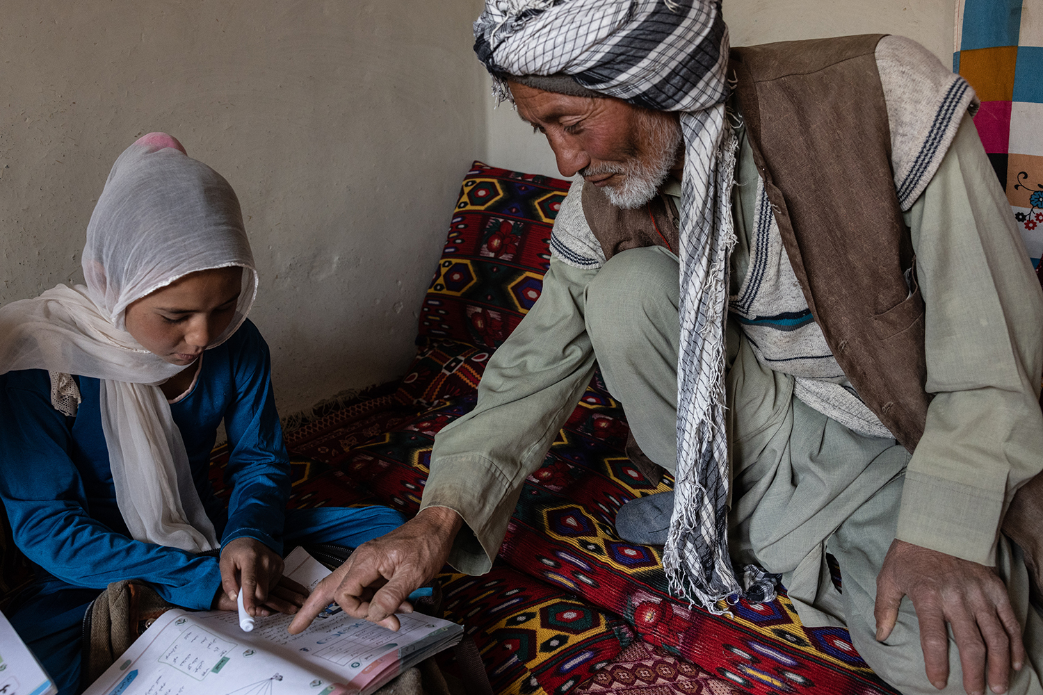 Roya, de diez años, estudia con su padre en Chil-Dokhtaran, provincia de Bamyan, el 21 de junio.