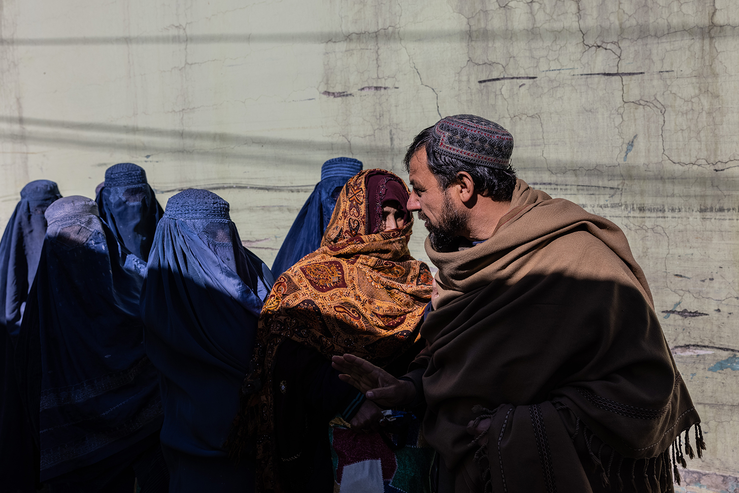 Un hombre pasa junto a un grupo de mujeres con velo en Kabul