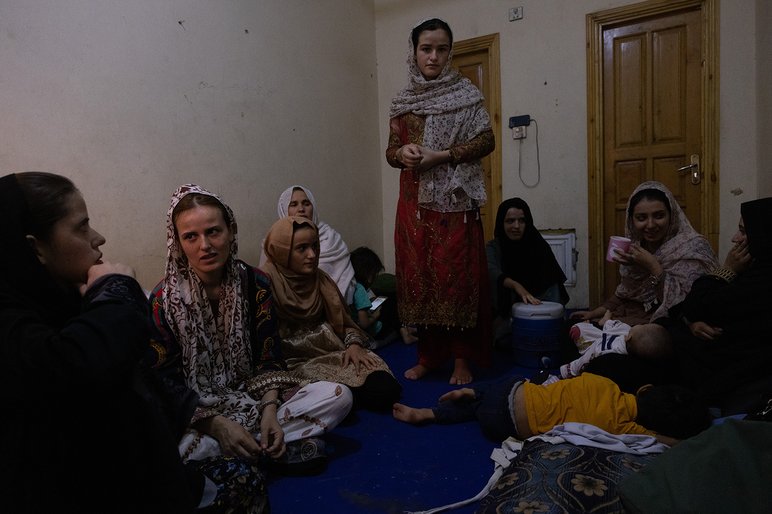 Las mujeres se reúnen en una habitación de hotel en Afganistán con la esperanza de huir del país hacia Pakistán.