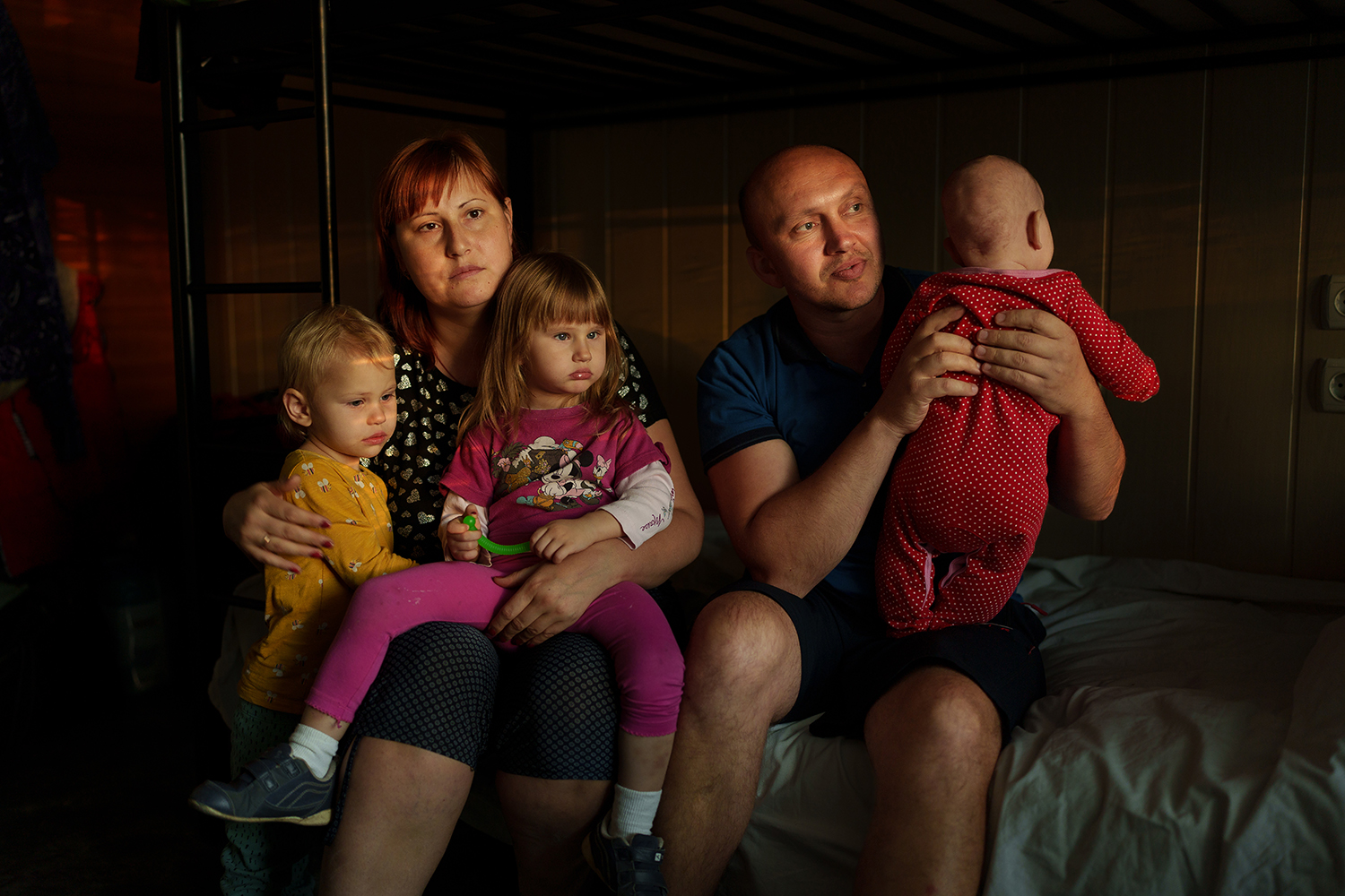 Andriy y Vika sostienen a sus hijos en un refugio.