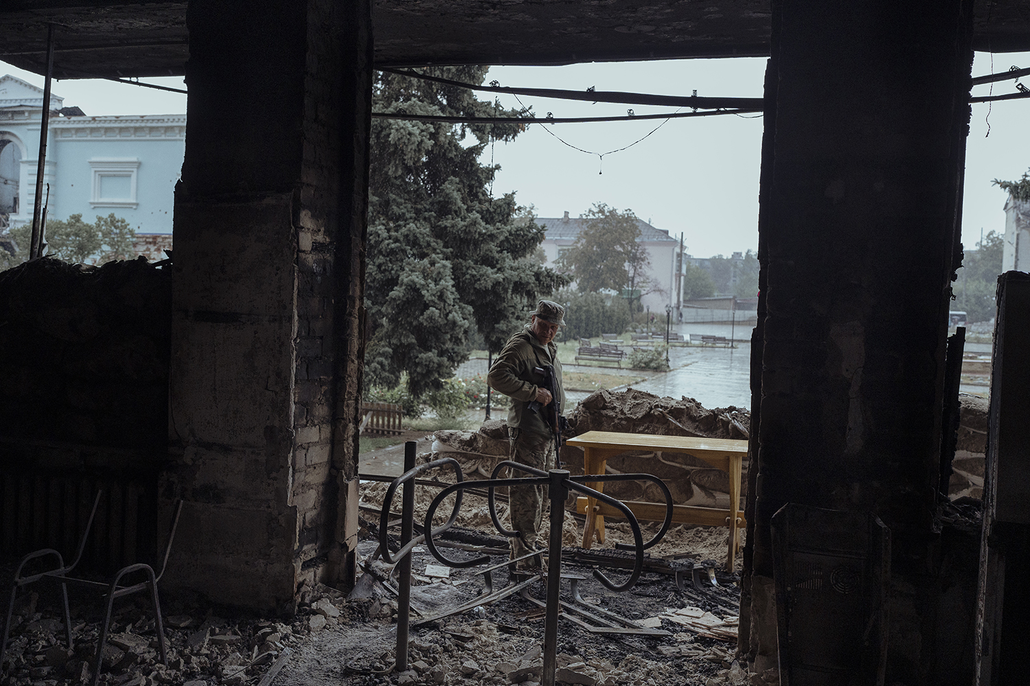 Un miembro de las fuerzas especiales ucranianas registra información sobre los edificios dañados en Izyum, Ucrania, tras la retirada de las fuerzas rusas.