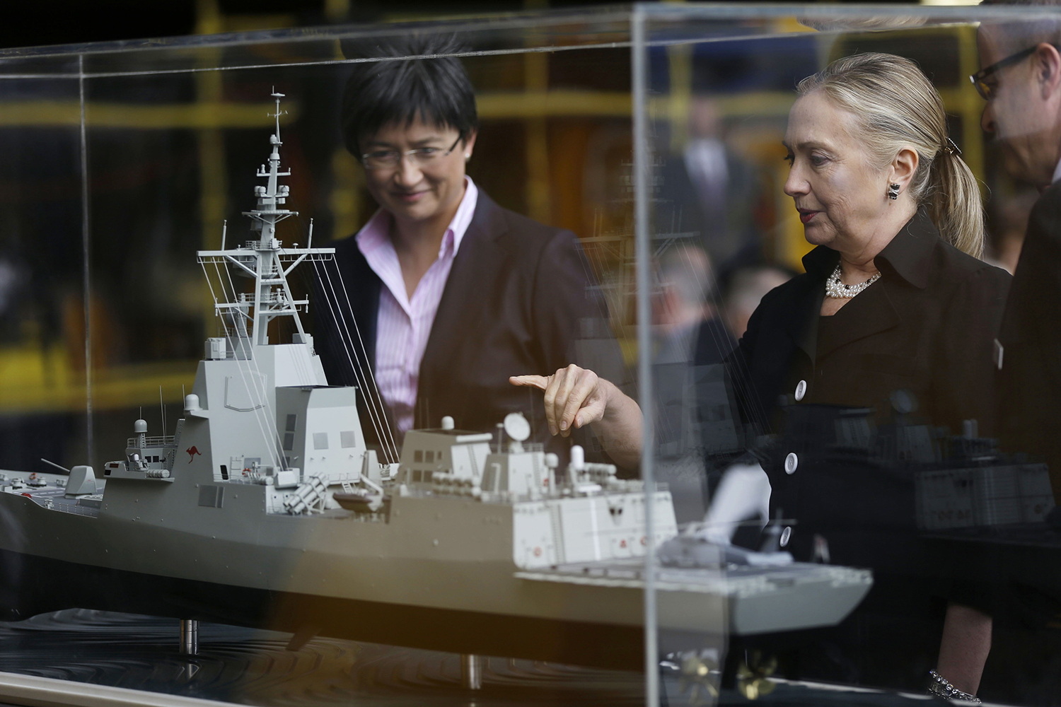 Wong y la entonces secretaria de Estado estadounidense Hillary Clinton ven un modelo de buque de guerra.