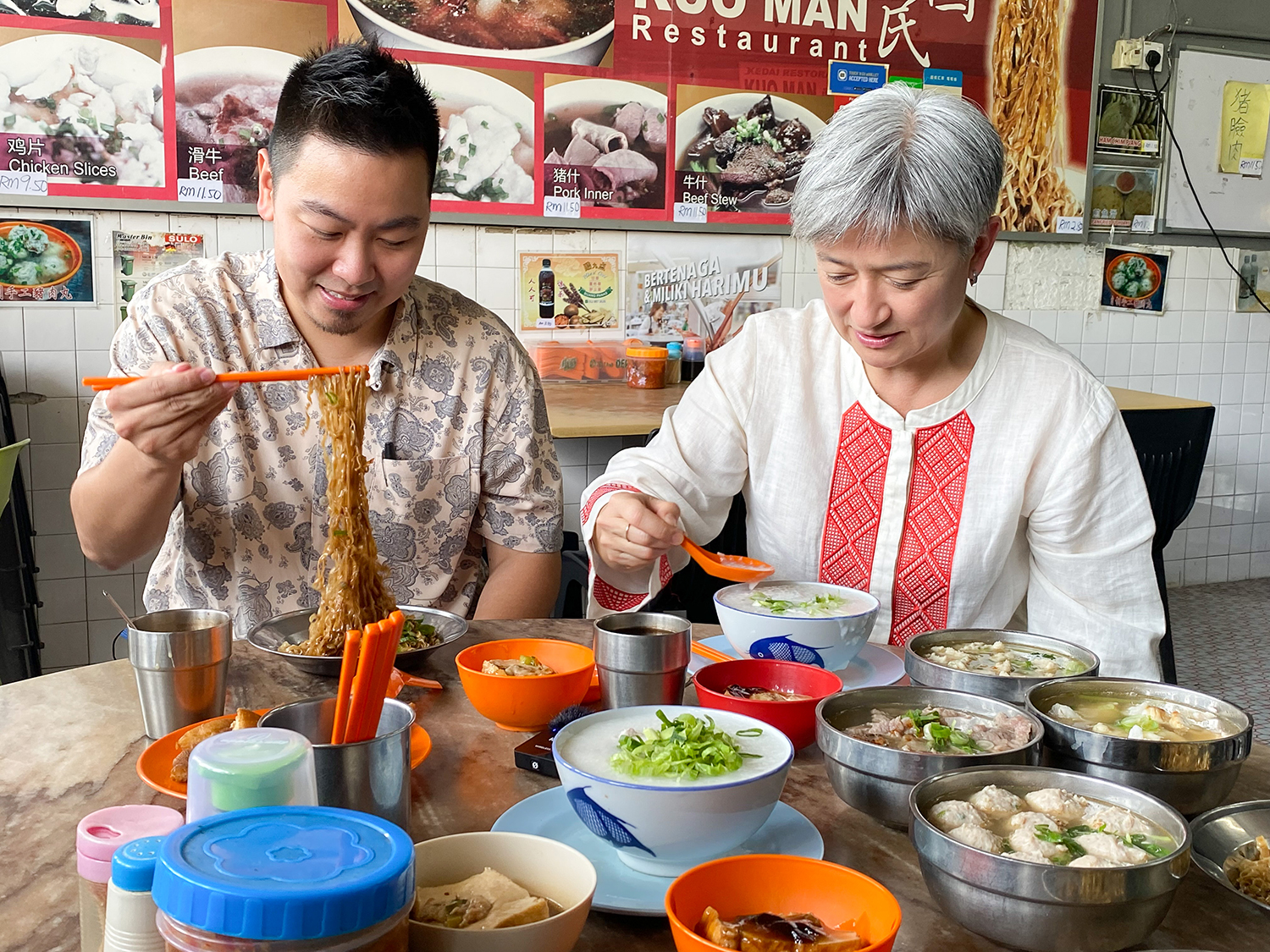 La ministra de Asuntos Exteriores australiana, Penny Wong, y su hermano menor, James Wong, comen en el famoso restaurante Kuo Man en Kota Kinabalu, Malasia.