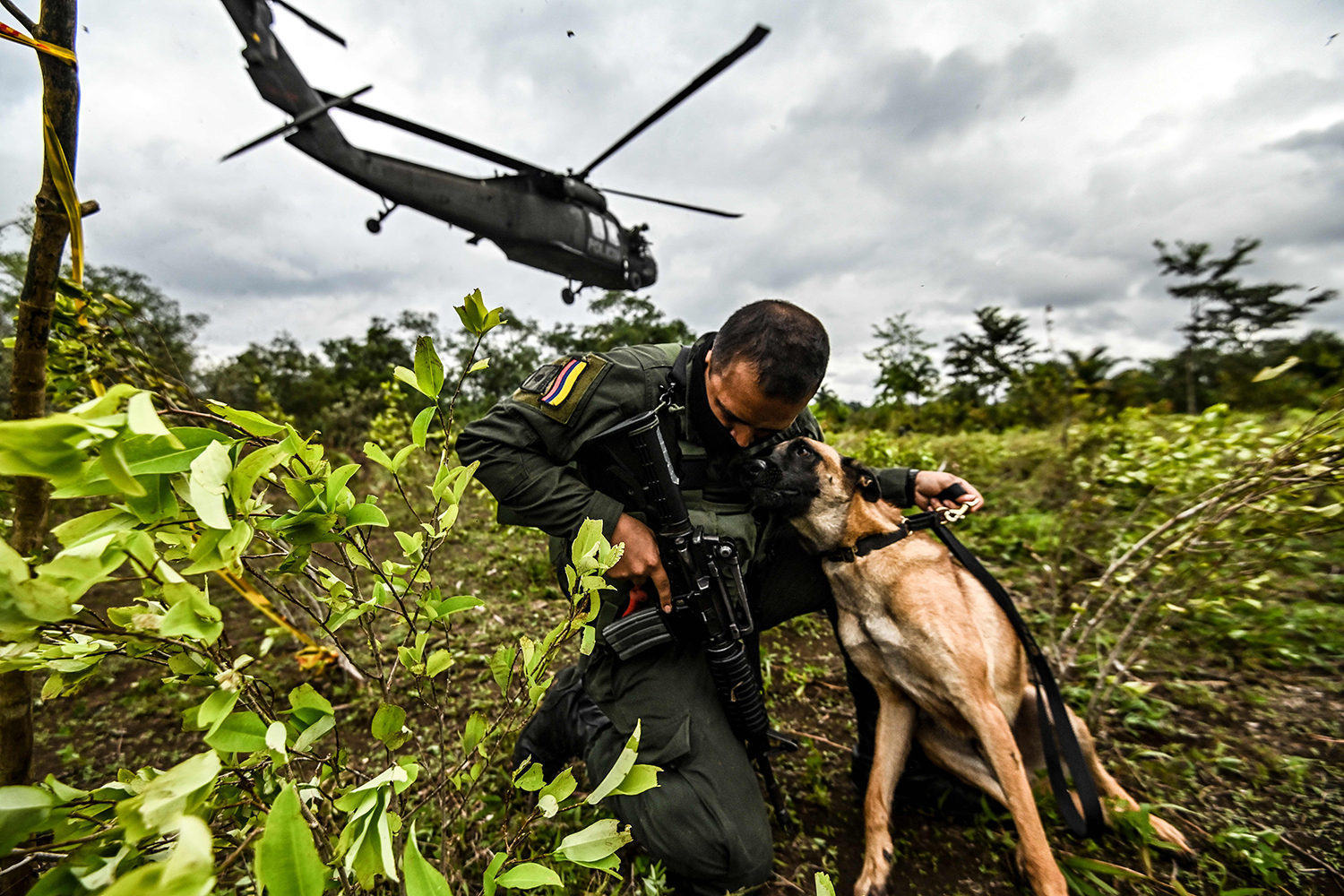 Un policía colombiano abraza a un perro.
