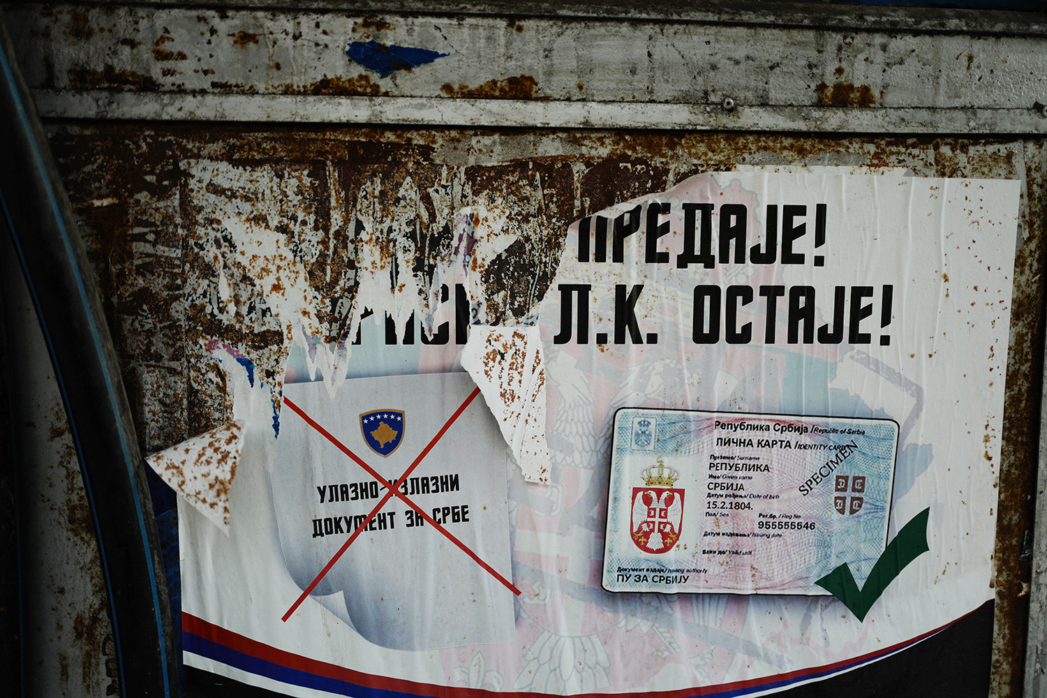 Un cartel en Mitrovica advierte a los serbios de etnia que no cambien su documentación por la exigida por el gobierno de Kosovo.