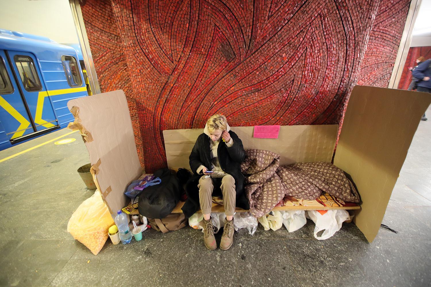 Una mujer prepara su lugar para dormir en una de las estaciones de metro de Kiev, Ucrania.