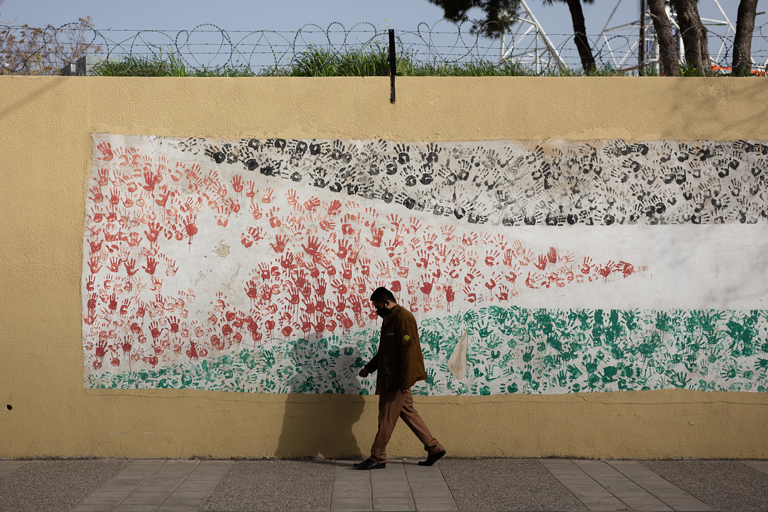 Un hombre camina junto a un mural de la bandera jordana en Ammán.