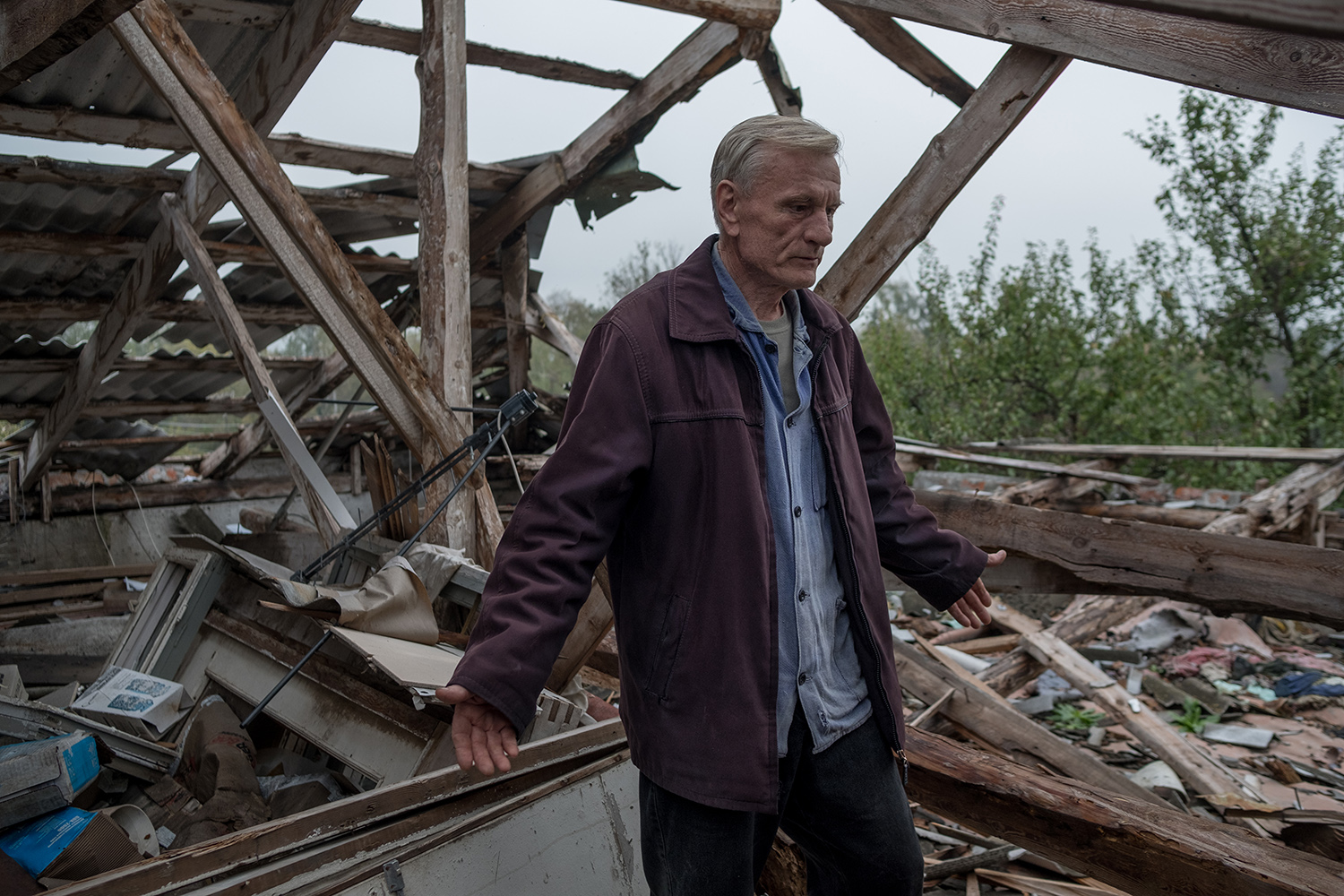 Anatoly se encuentra en las ruinas de su casa, que fue destruida por las fuerzas rusas, en Lyptsi, Ucrania.