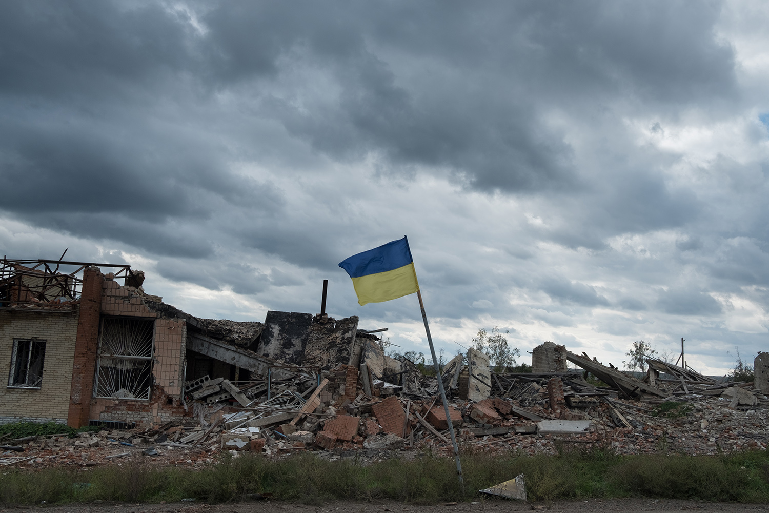 Una bandera ucraniana ondea sobre las ruinas del pueblo destruido de Dolyna.