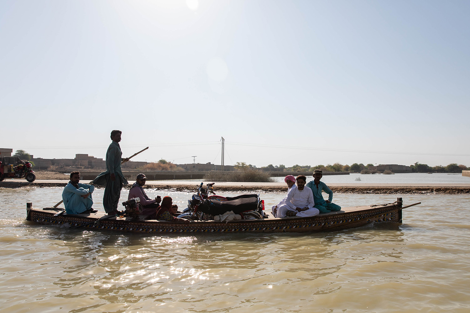 Varias personas recorren en barca las zonas inundadas de Dadu, Pakistán.