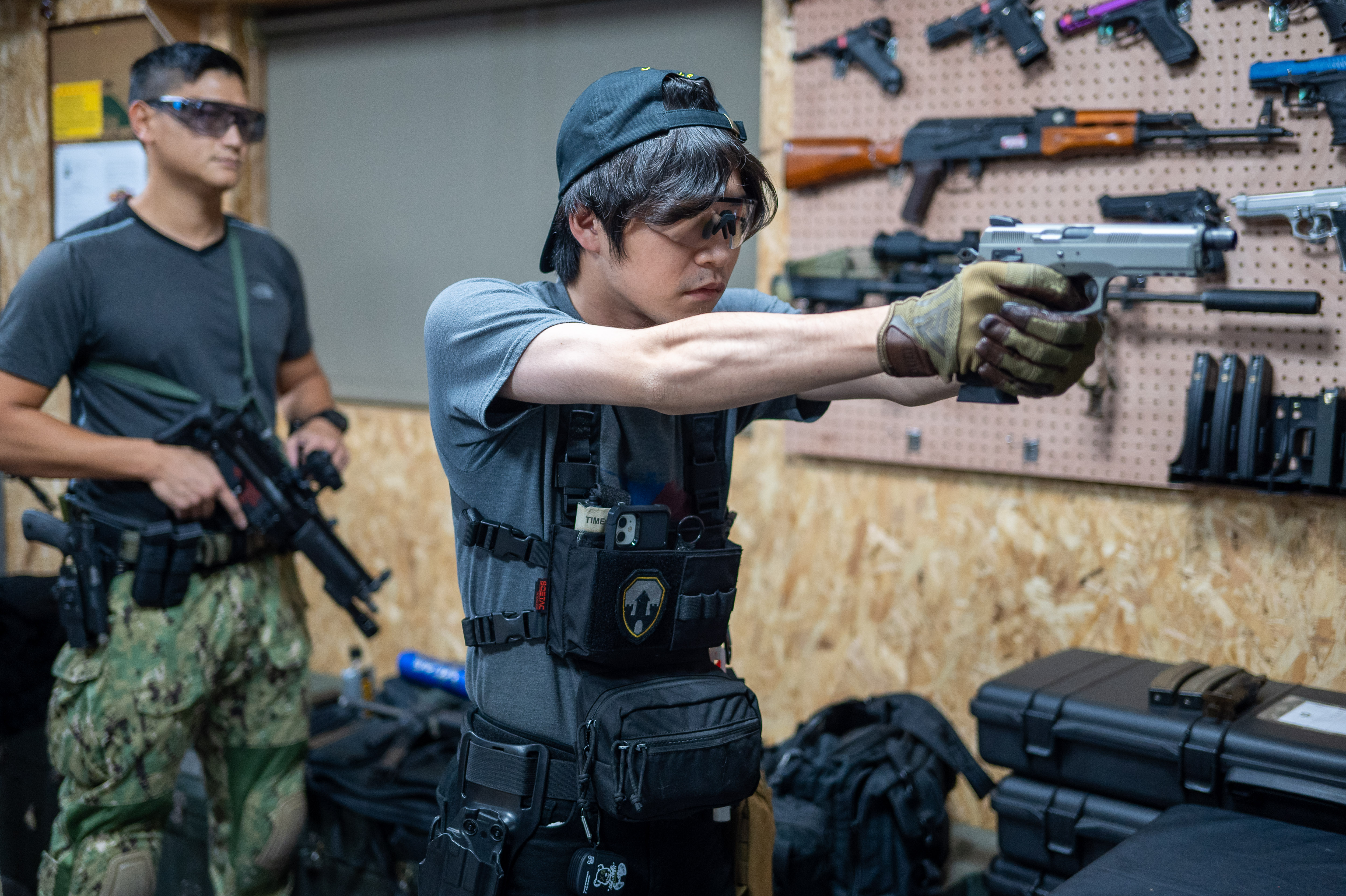 Shaun Tai (derecha) dispara una pistola de airsoft durante un entrenamiento con armas de fuego en el Campamento 66, un campo de tiro e instalación de entrenamiento dirigido por dos antiguos marines en Taipei, Taiwán, el 6 de diciembre.
