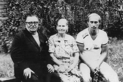 Una foto en blanco y negro muestra a un joven Putin sentado en un banco junto a su madre y su padre.