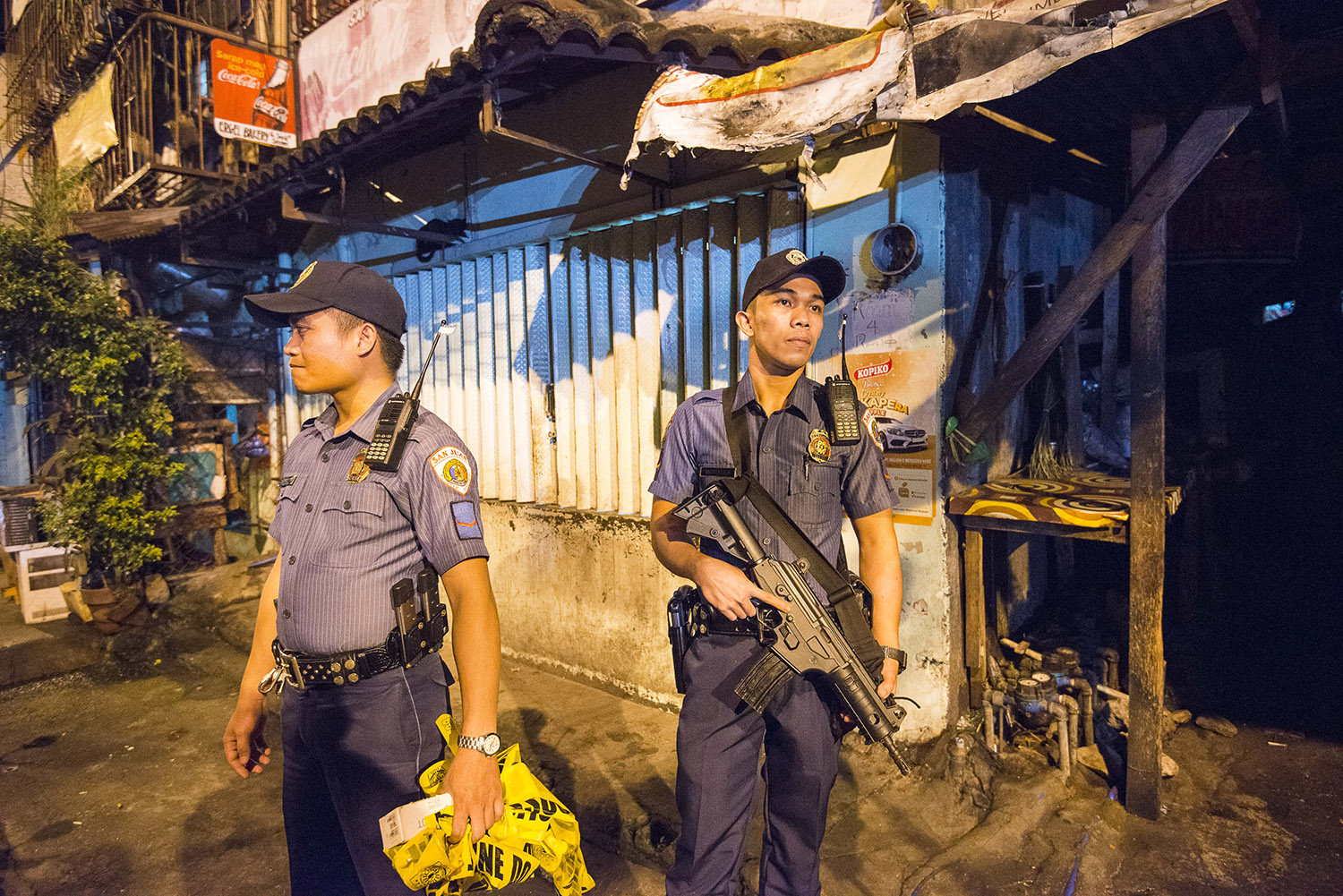 Agentes de policía permanecen fuera de la escena de una "redada de compra" operación en Filipinas que se saldó con la muerte a tiros por la policía de un presunto traficante de drogas en 2016.